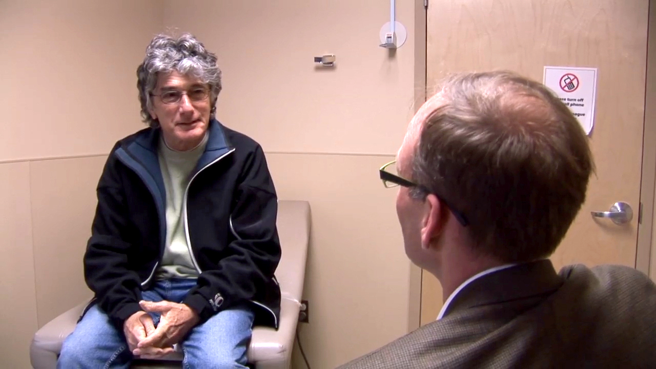 Man sitting in exam room talking with a Behavioral Health Professional.
